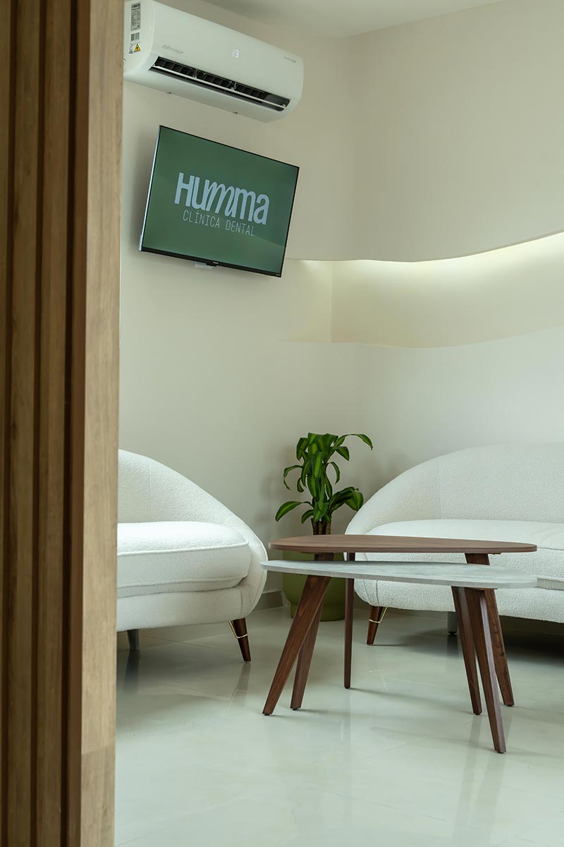 Sala de espera con sillones y pantalla en Clínica Dental Humma en Mérida, Yucatán